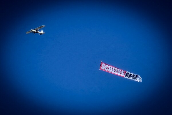Ein Flugzeug am Himmel, das ein Spruchband mit der Aufschrift "Scheiss AfD" zieht.